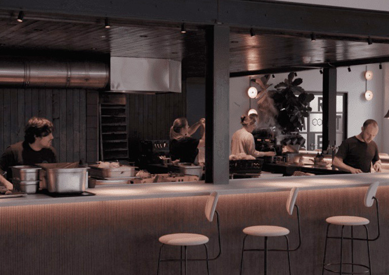 An open plan kitchen with four people at work in the kitchen